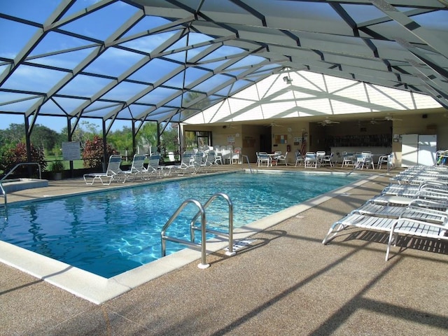 view of swimming pool featuring a patio, ceiling fan, and a lanai