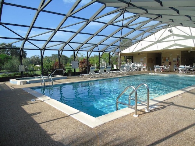 view of swimming pool with a lanai, a patio, and an in ground hot tub