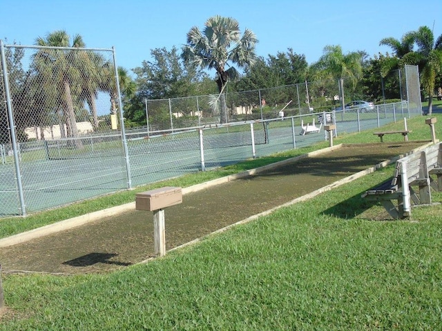 view of tennis court featuring a yard