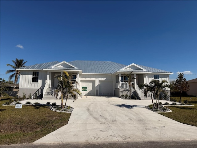 view of front of home with a porch, a garage, and a front lawn