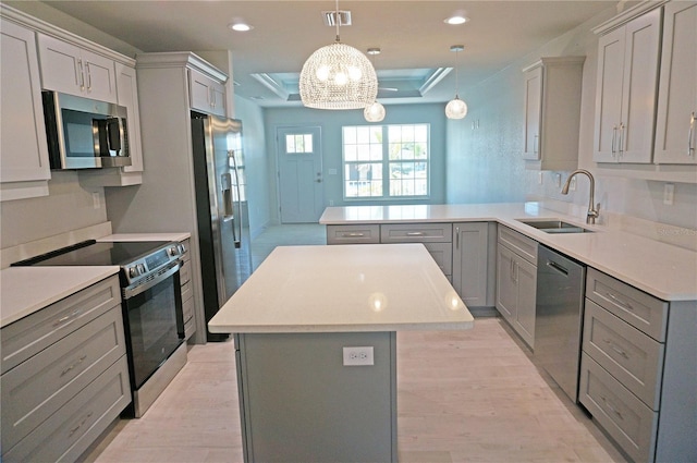 kitchen featuring gray cabinetry, pendant lighting, a center island, sink, and stainless steel appliances