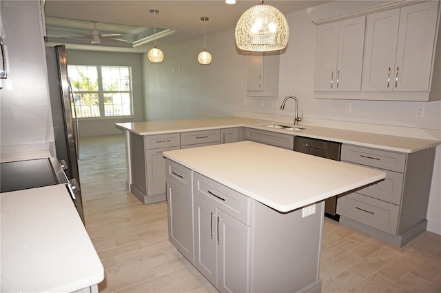 kitchen featuring dishwasher, sink, a center island, pendant lighting, and gray cabinets