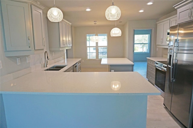 kitchen with kitchen peninsula, stainless steel appliances, hanging light fixtures, and sink