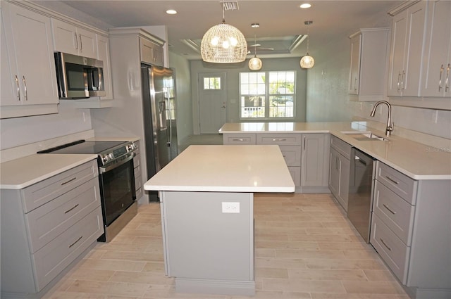 kitchen with kitchen peninsula, stainless steel appliances, gray cabinets, and sink