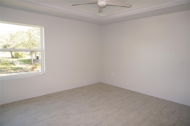 empty room with ceiling fan, crown molding, a wealth of natural light, and light hardwood / wood-style flooring