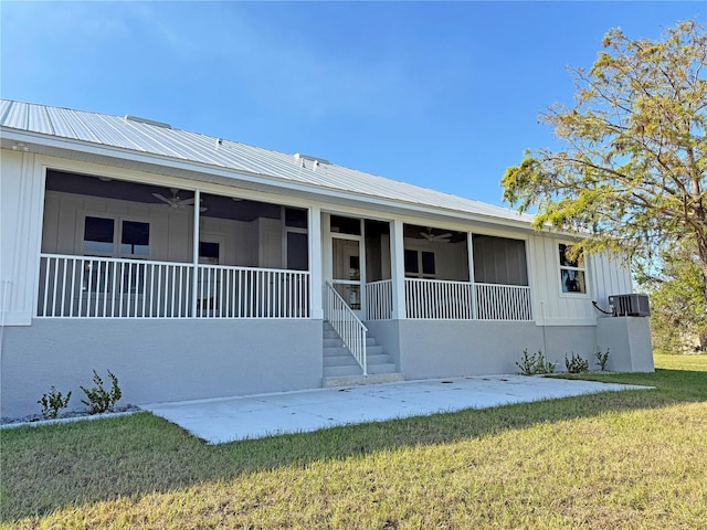 view of front facade with a front lawn, cooling unit, and ceiling fan