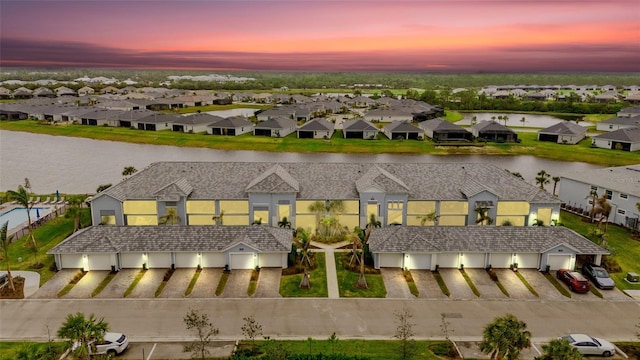 aerial view at dusk featuring a water view