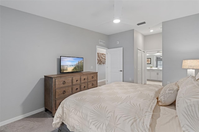 bedroom featuring connected bathroom, light colored carpet, and ceiling fan