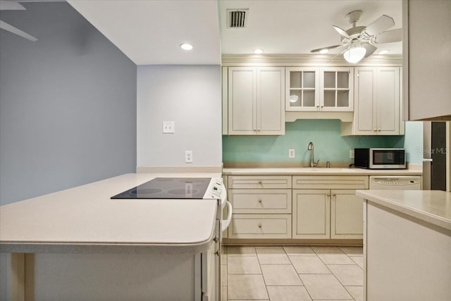 kitchen featuring cream cabinetry, electric range, ceiling fan, and sink