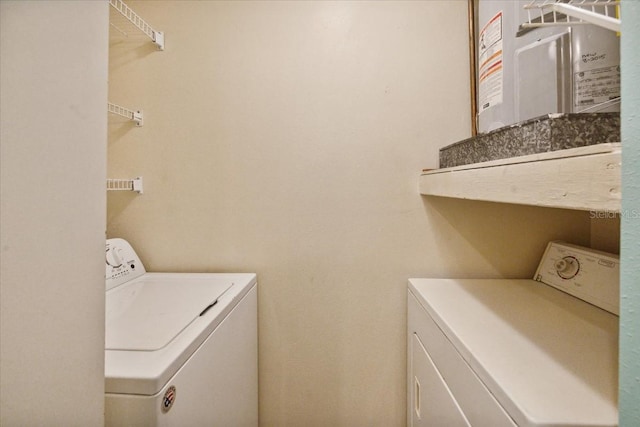 laundry room featuring washing machine and dryer and water heater