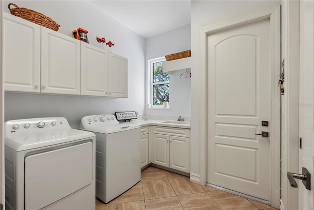 clothes washing area featuring sink, light tile patterned flooring, cabinets, and independent washer and dryer