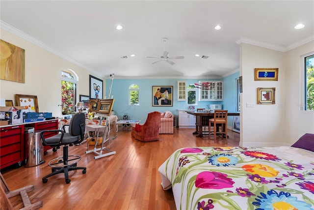 bedroom featuring ceiling fan, light wood-type flooring, and crown molding