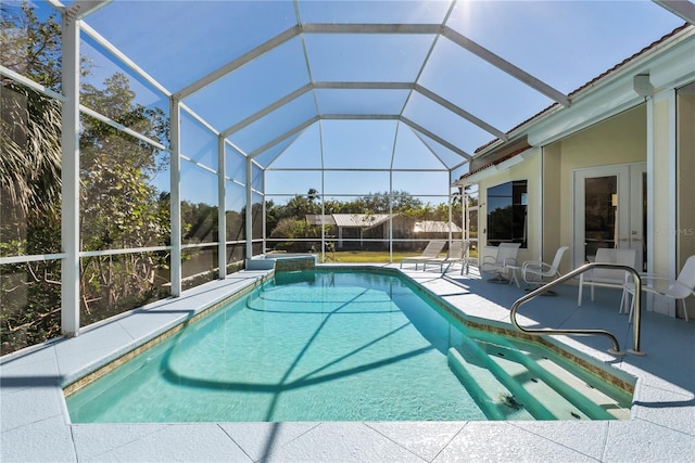 view of pool with glass enclosure and a patio