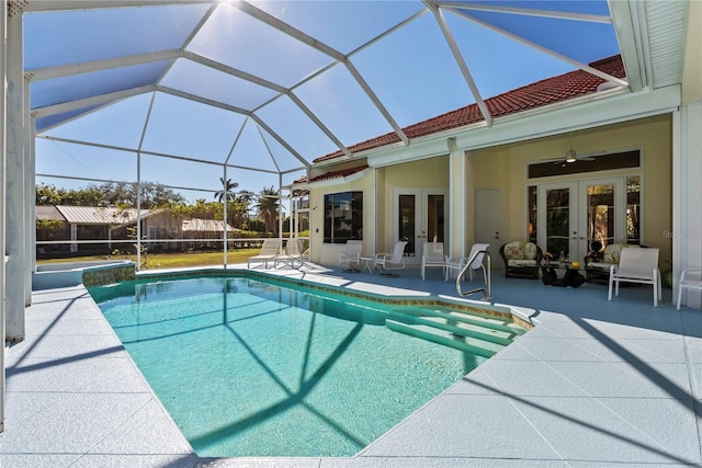 view of pool featuring glass enclosure, a patio area, french doors, and ceiling fan