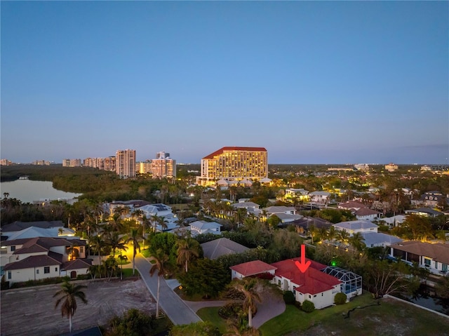 aerial view at dusk featuring a water view