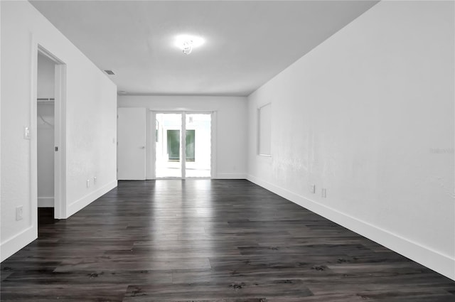 unfurnished room with dark hardwood / wood-style flooring