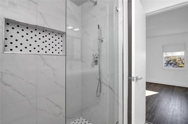 bathroom featuring hardwood / wood-style floors and a tile shower