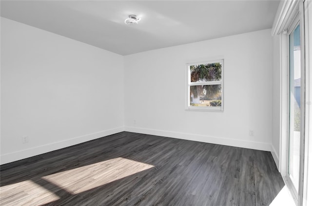 empty room with dark hardwood / wood-style flooring