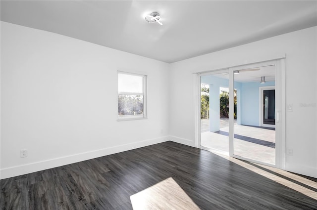 spare room with a healthy amount of sunlight and dark hardwood / wood-style flooring