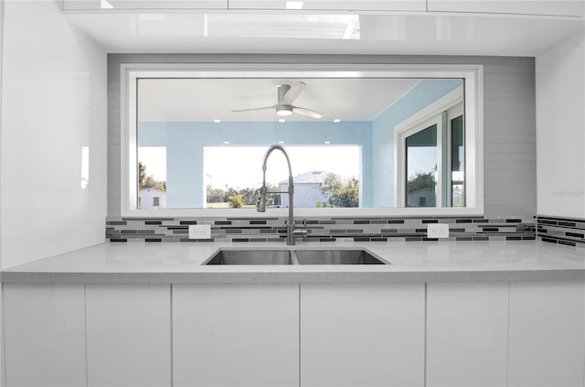 kitchen featuring backsplash, white cabinetry, and sink