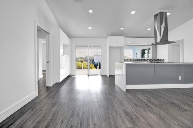 kitchen with kitchen peninsula, white cabinetry, dark hardwood / wood-style floors, and island range hood