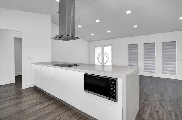 kitchen featuring dark hardwood / wood-style flooring, extractor fan, lofted ceiling, black electric stovetop, and white cabinets