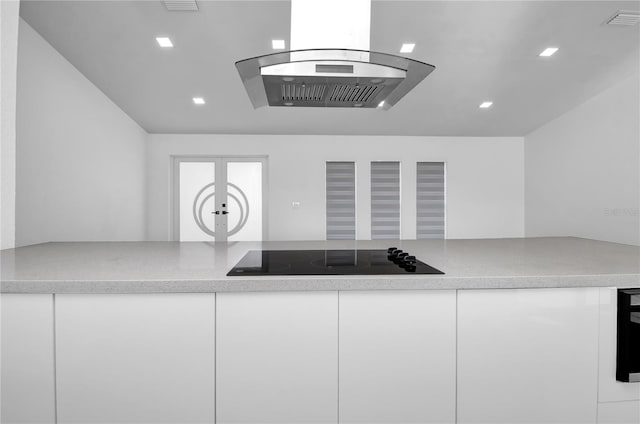 kitchen featuring island exhaust hood, black electric cooktop, and white cabinetry