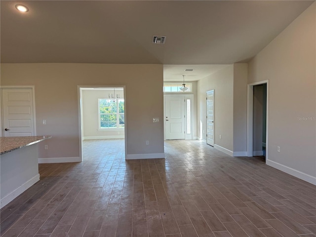 unfurnished living room featuring dark wood-style floors, visible vents, and baseboards