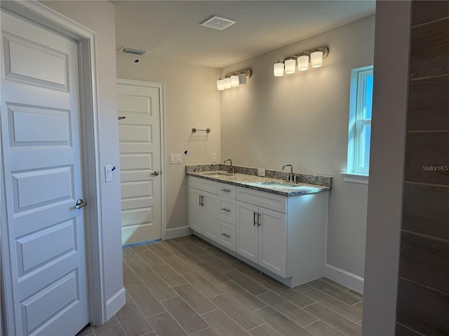 full bathroom with a sink, visible vents, and baseboards