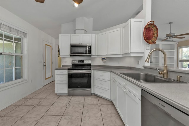 kitchen featuring white cabinets, light tile patterned flooring, sink, and appliances with stainless steel finishes