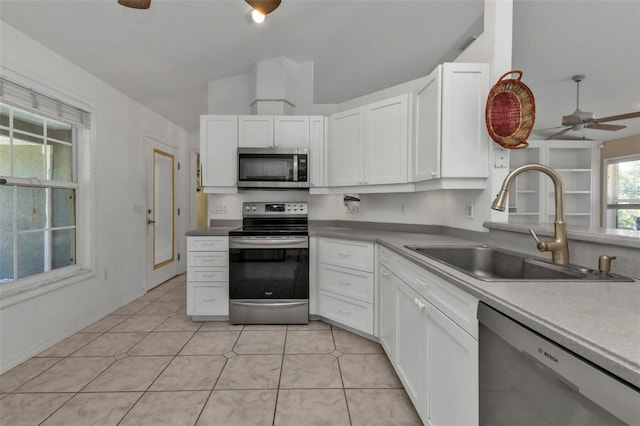 1811 Music Ln, North Port, FL 34286 - kitchen with appliances with stainless steel finishes, a sink, a ceiling fan, and white cabinetry