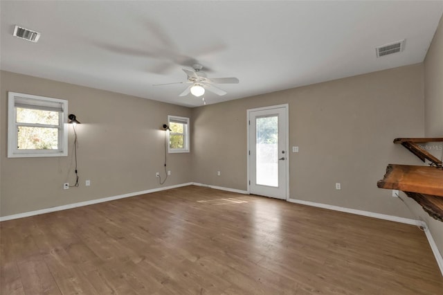 unfurnished living room featuring a wealth of natural light, ceiling fan, and hardwood / wood-style flooring