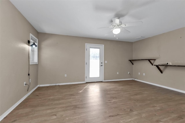 1811 Music Ln, North Port, FL 34286 - unfurnished living room featuring a ceiling fan, wood finished floors, and baseboards