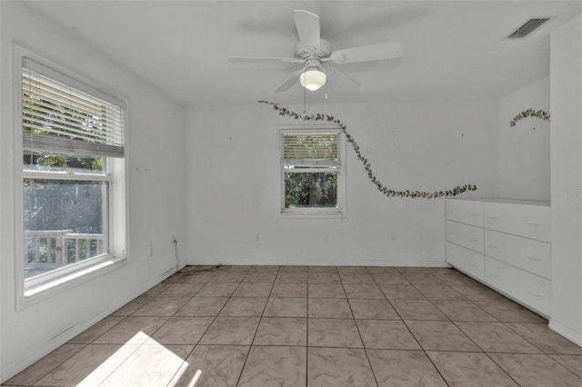 tiled spare room featuring ceiling fan