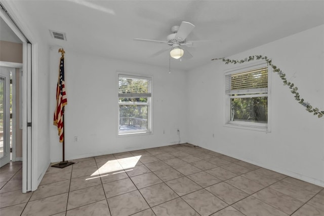 tiled empty room featuring ceiling fan