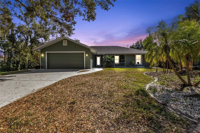 1811 Music Ln, North Port, FL 34286 - ranch-style home with an attached garage, driveway, covered porch, stucco siding, and a lawn