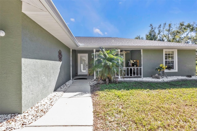1811 Music Ln, North Port, FL 34286 - property entrance featuring stucco siding, a yard, a porch, and roof with shingles