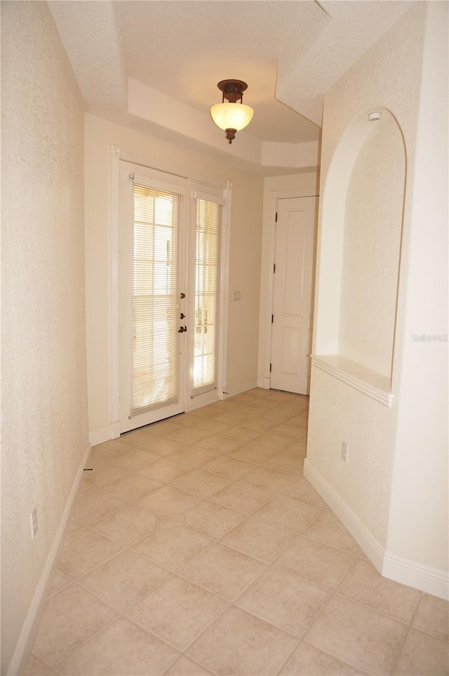 spare room with french doors and a raised ceiling