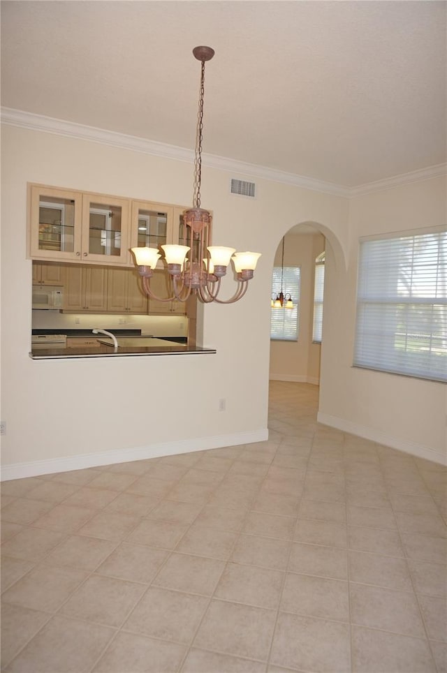 interior space with light tile patterned floors, ornamental molding, and a notable chandelier