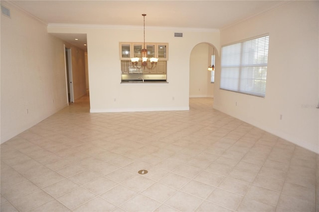 empty room with crown molding and a notable chandelier