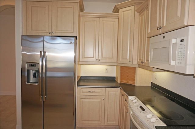 kitchen featuring stainless steel fridge, stove, and light brown cabinets