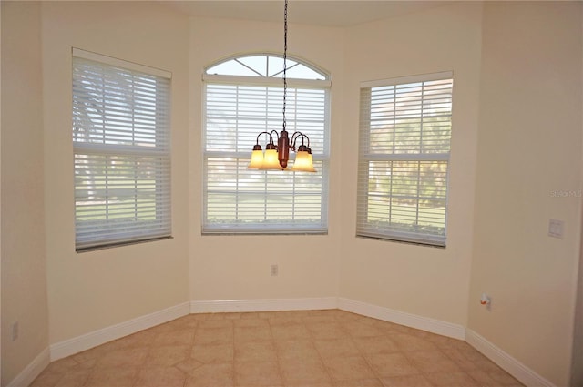 unfurnished room featuring a chandelier