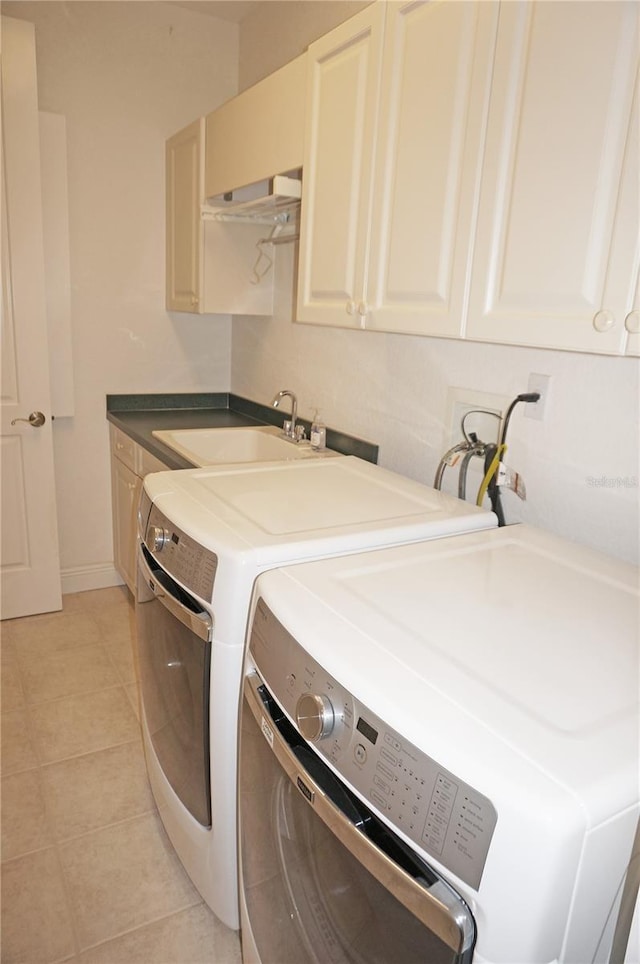 laundry room with sink, light tile patterned floors, cabinets, and independent washer and dryer