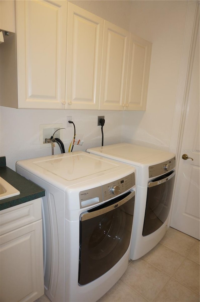 laundry room featuring cabinets, separate washer and dryer, and light tile patterned floors