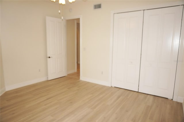 unfurnished bedroom with light wood-type flooring and a closet