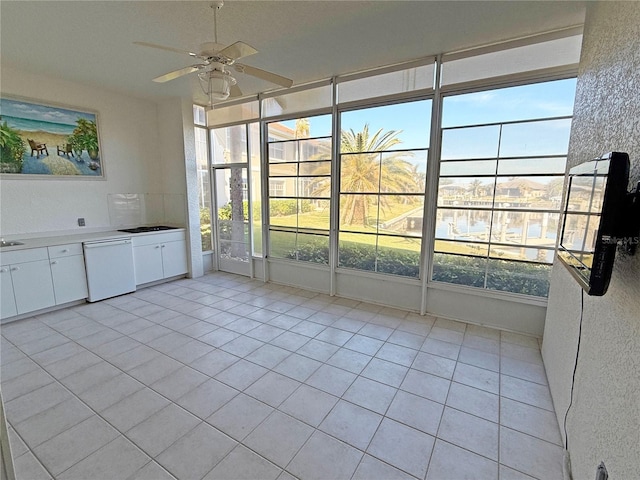 unfurnished sunroom featuring ceiling fan and sink