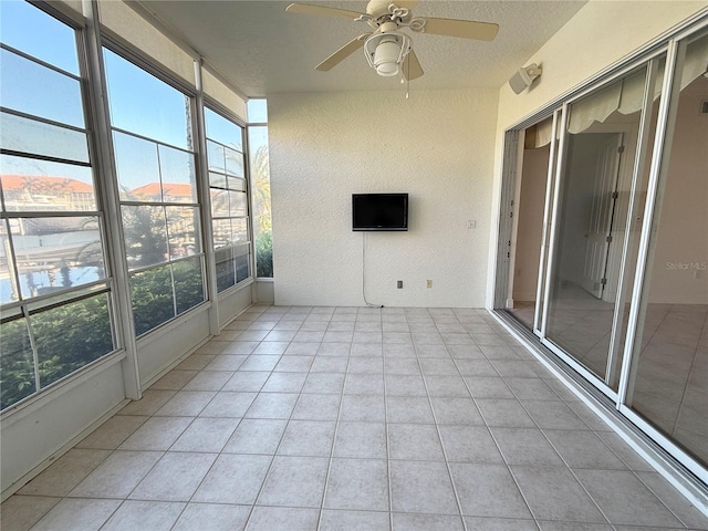 unfurnished sunroom with ceiling fan