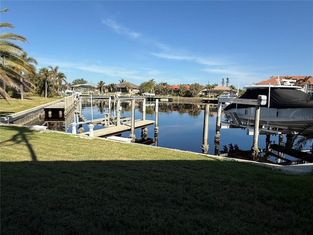 view of dock featuring a lawn and a water view