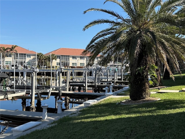 dock area with a water view and a lawn