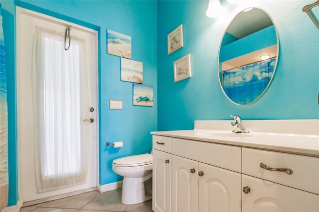 bathroom featuring tile patterned floors, vanity, toilet, and walk in shower